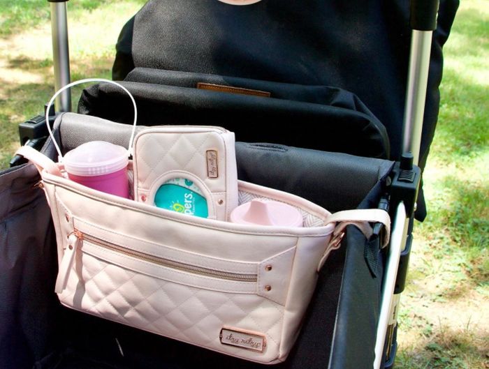 A reviewer's photo showcasing the stroller organizer in a soft blush color