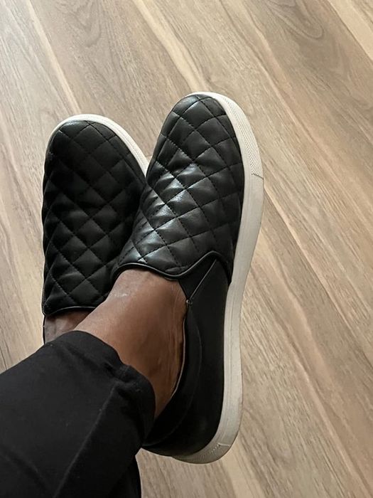 Reviewer sporting quilted black sneakers