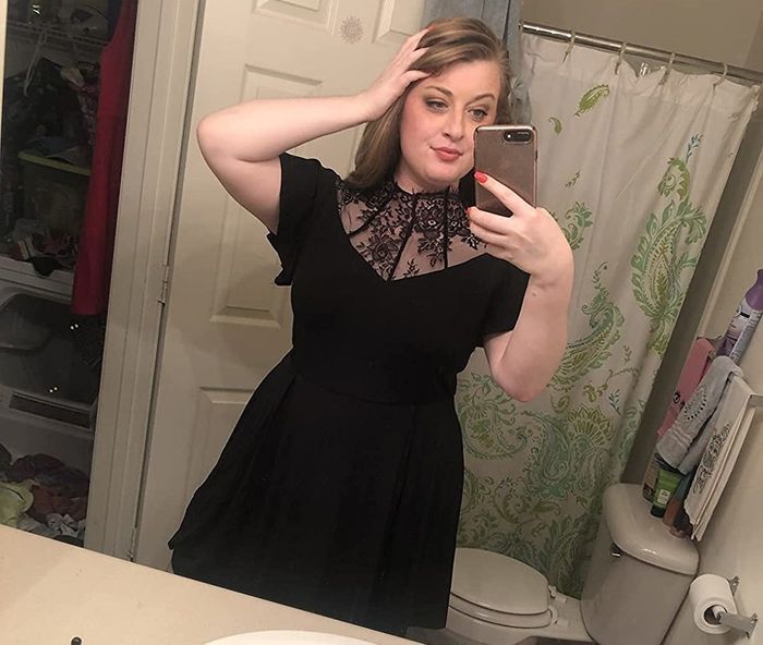 Reviewer styling a black dress featuring a lace mesh neckline
