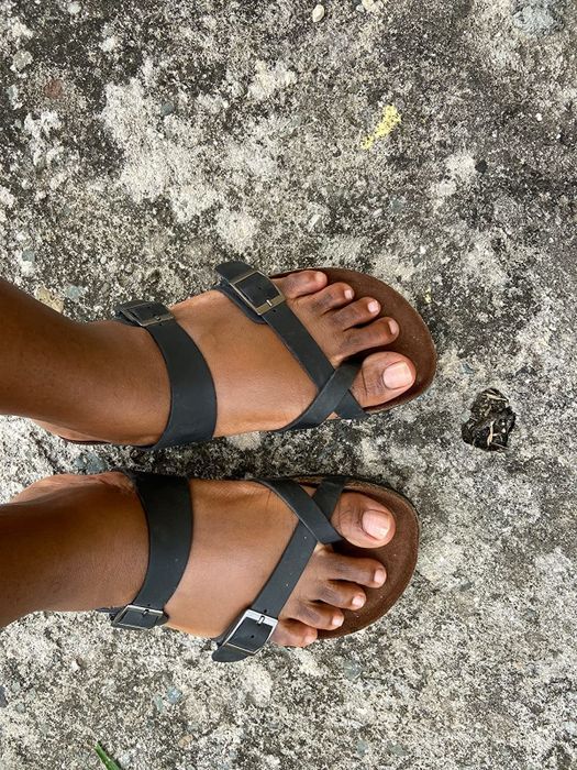 Reviewer wearing black leather cross-band footbed sandals.