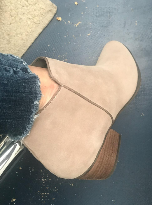 Reviewer wearing the same ankle boots in the sand suede color.
