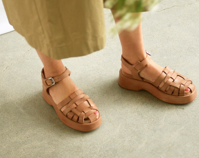 a model showcasing the sandals in tan