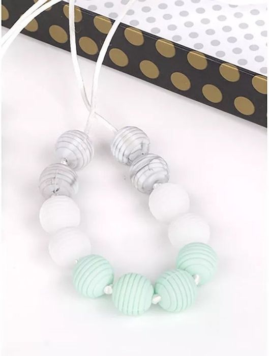 A beaded necklace featuring striped and smooth beads, presented in a gift box