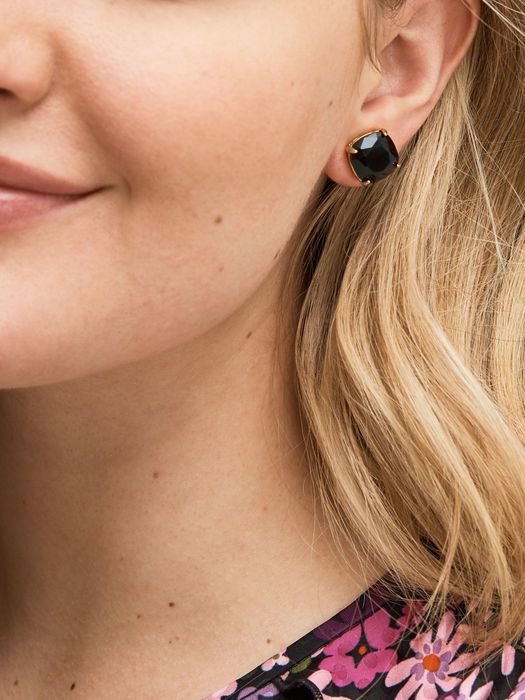 Model wearing a black stud earring on her left ear