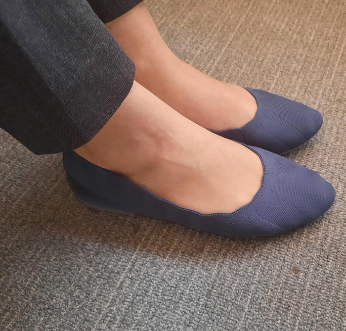 A reviewer showcasing the blue flats.