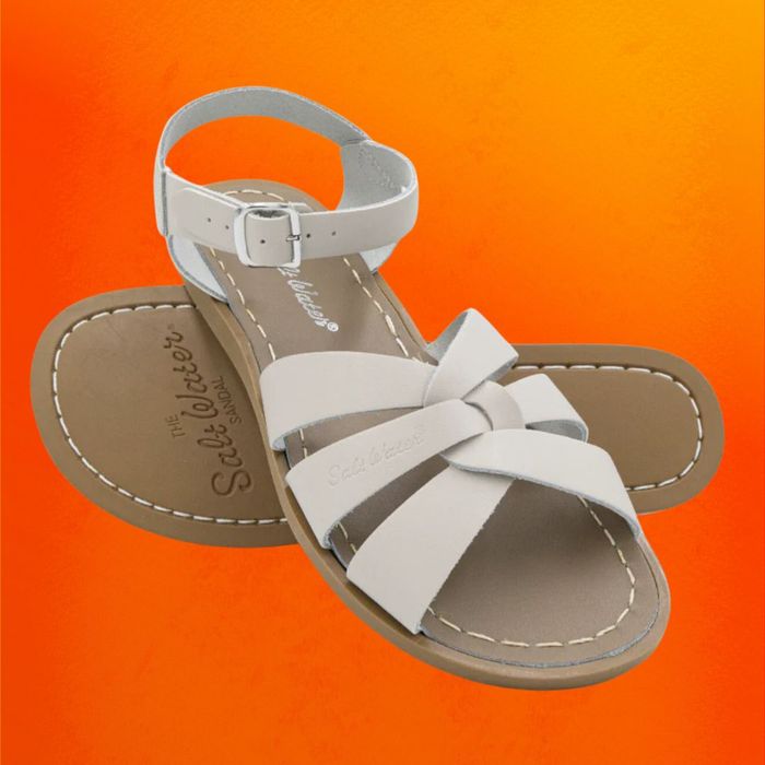 The Salt Water Original sandals in white, displayed on an orange background