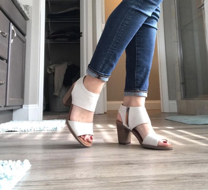 A side view of a reviewer wearing a block heel with a white, thick-strapped top.