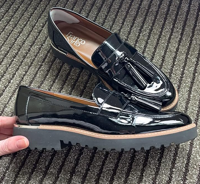 A pair of sleek black loafers with decorative tassels.