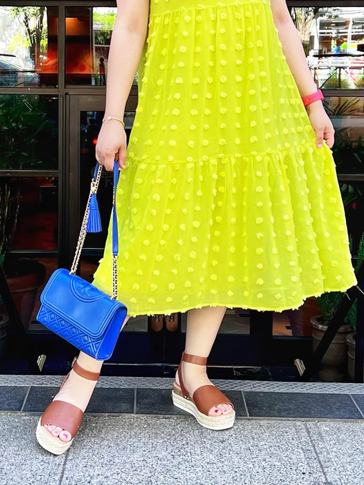 Reviewer wearing brown sandals paired with a green dress.