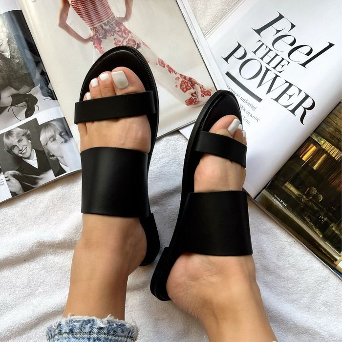 a model showcasing the sandals in black