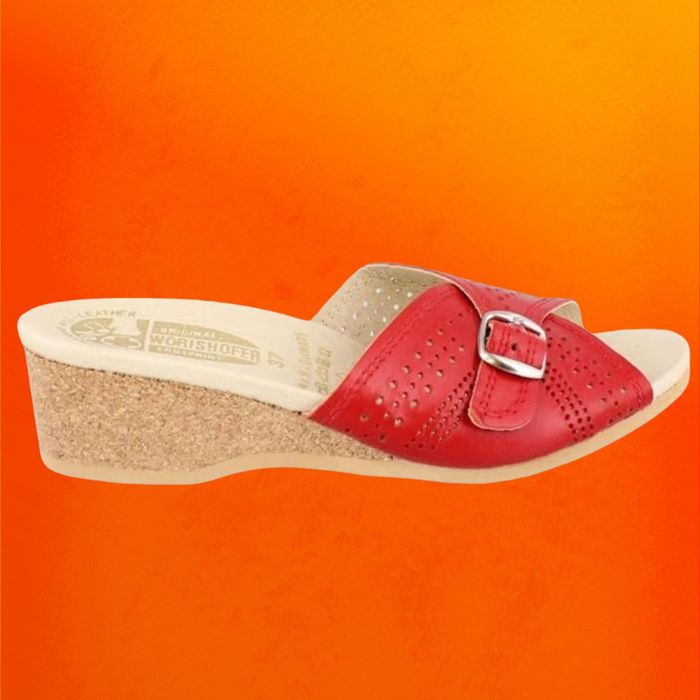 Red slide sandals featuring a cork sole, set against an orange backdrop