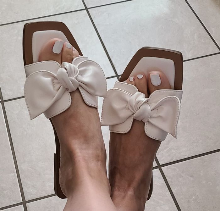a reviewer showcasing the sandals in white