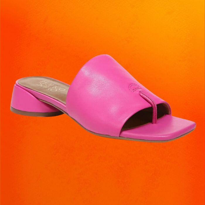 Pink slide sandals featuring a subtle block heel, set against an orange backdrop
