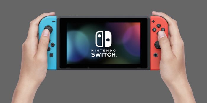 Hands holding a Nintendo Switch console, ready for play.
