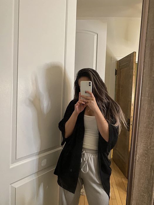 Reviewer modeling a thick black poncho