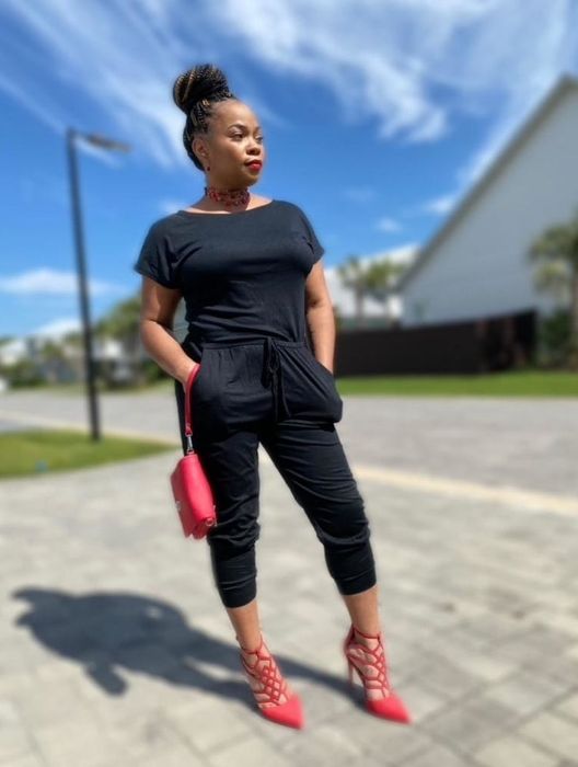 Reviewer showcasing a black off-the-shoulder jumpsuit
