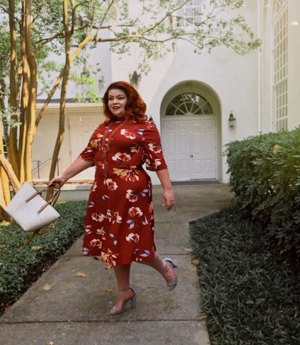 reviewer wearing the red dress paired with blue heels and a white bag