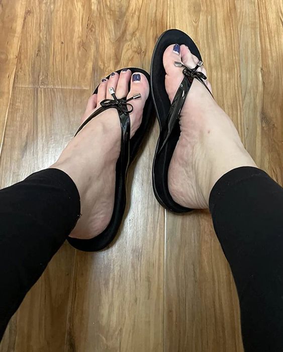 A reviewer is pictured wearing the black Vionic sandals