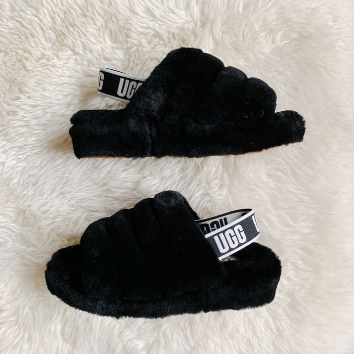 These plush slippers come with a strap around the back adorned with the Ugg logo, offering a blend of comfort and chic style for their daily wear.