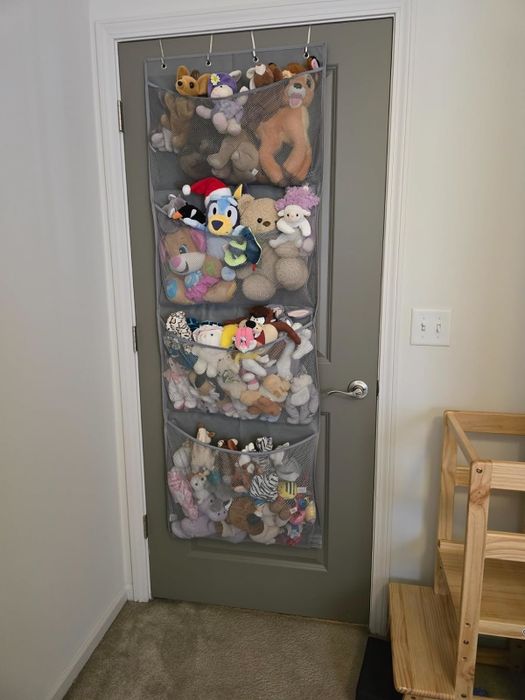 A door-hanging organizer filled with a collection of plush toys, offering a space-saving solution for keeping everything neatly stored away.