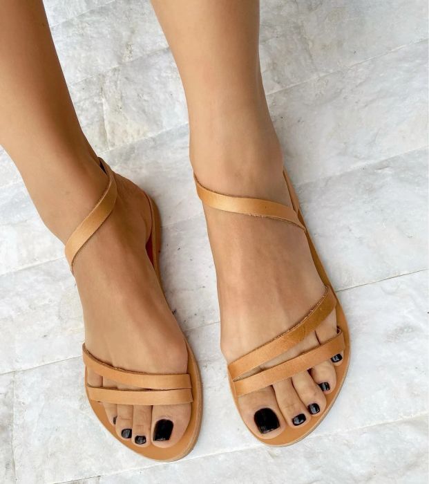 A model’s feet are pictured wearing the tan sandals