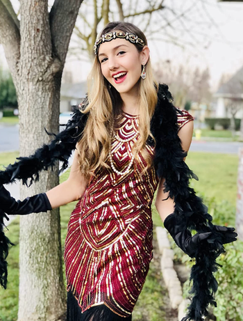 reviewer wearing a red dress with '20s-style accessories