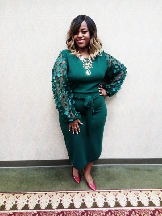 The reviewer is seen wearing the mid-calf length dress in a vibrant green shade.