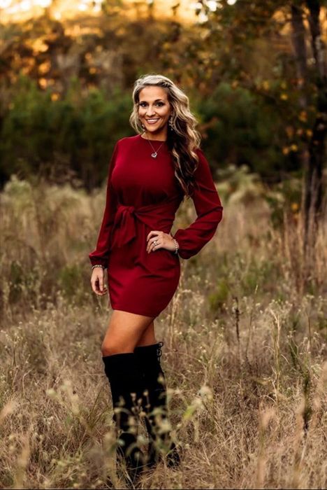 reviewer wearing the burgundy dress paired with black knee-high boots