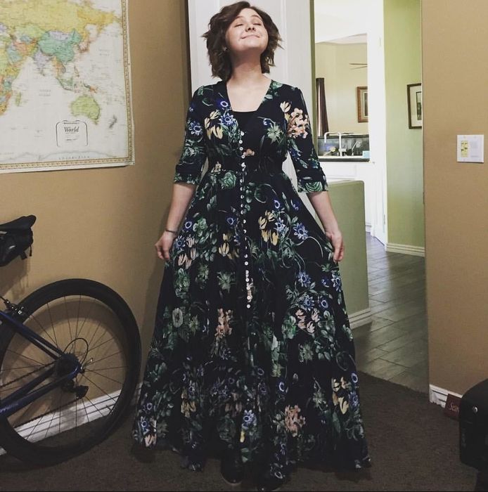 reviewer wearing the dark green floral-print dress