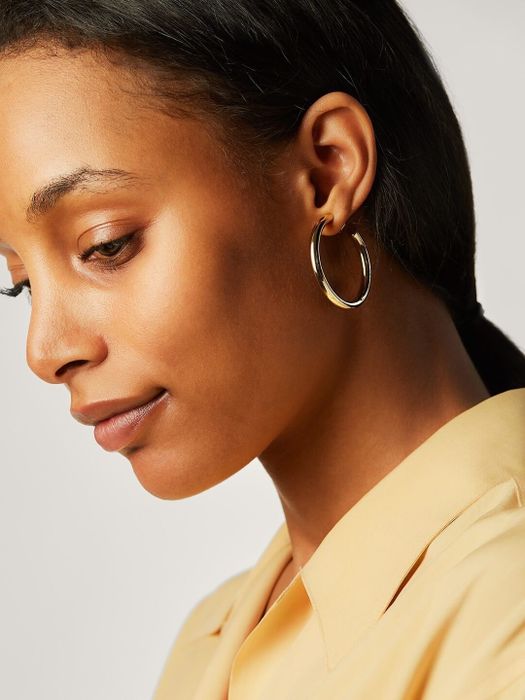 The model is seen wearing gold hoop earrings.