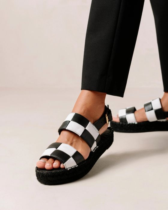 A model is pictured wearing the black and white checkered sandals