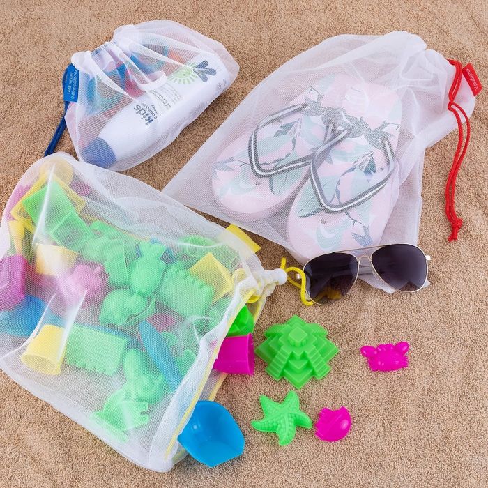 A set of mesh bags alongside beach essentials like flip-flops, sunglasses, and sand toys, all perfect for organizing your outdoor gear.