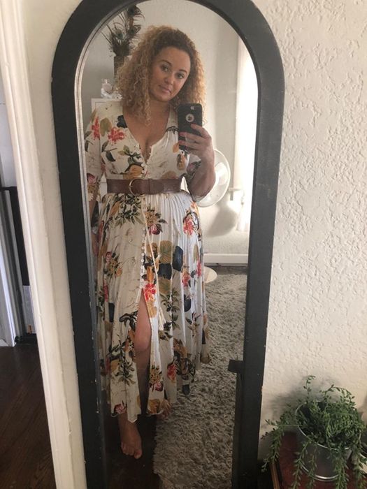 reviewer wearing the white dress adorned with colorful floral patterns