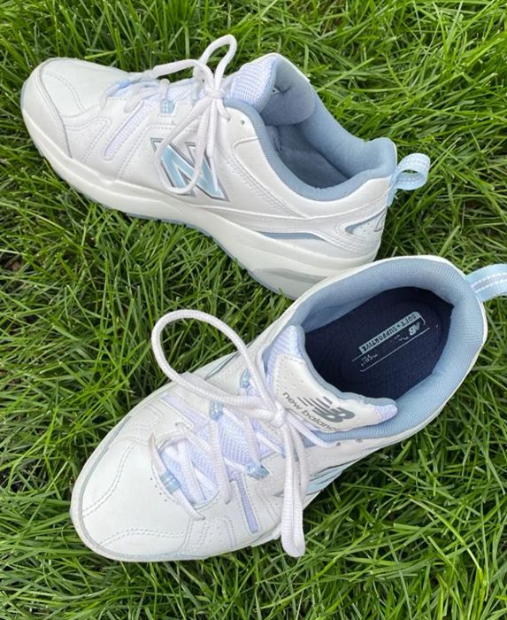A reviewer shares a photo of the white and blue sneakers placed on a grassy area
