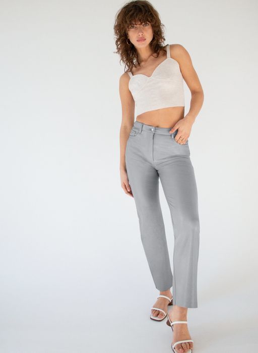 The model is wearing the cropped faux leather pants in a striking blue shade.
