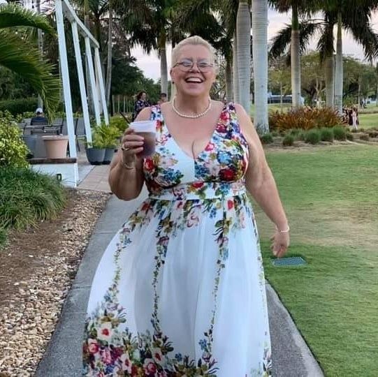 reviewer wearing the white dress with vibrant floral patterns