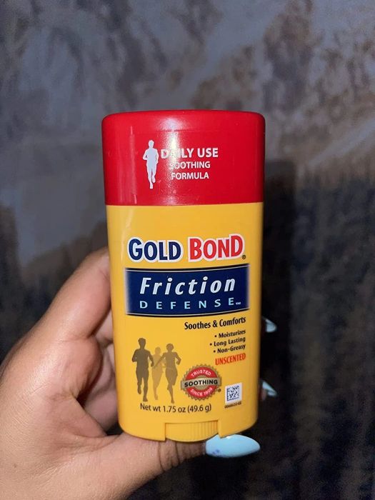 A reviewer holding up a tube of friction defense product