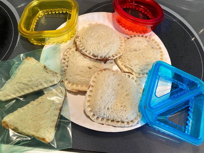 Assorted sandwich cutters with sandwiches shaped into various designs, perfect for adding creativity to meal preparation