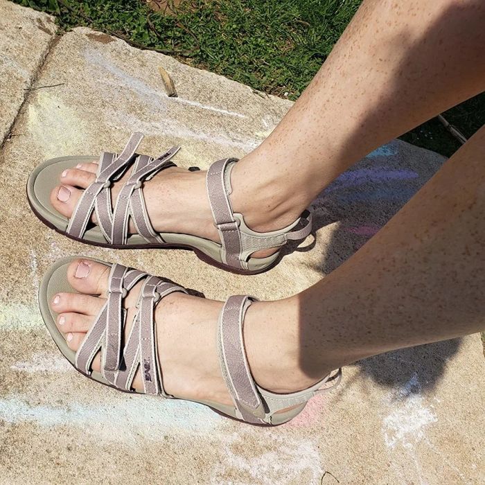 A reviewer is pictured wearing the tan sandals with mauve straps