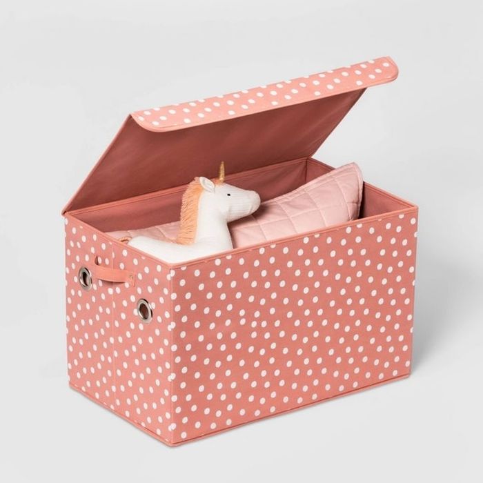 A polka-dotted storage box featuring a plush unicorn and a soft pink cushion inside, adding both style and comfort to your storage solutions.