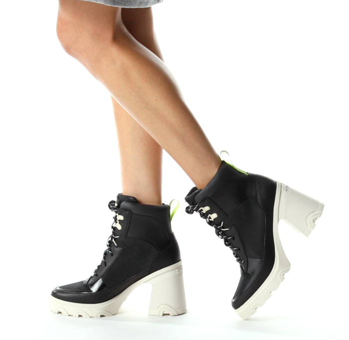 A model wears the black-and-white chunky-heeled lace-up boots.