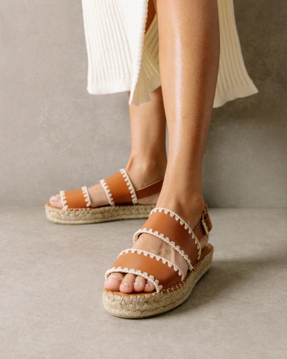 A model is shown wearing the tan espadrille sandals