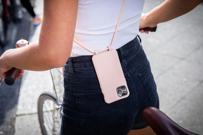 A model rides a bike with their phone securely strapped in a crossbody case