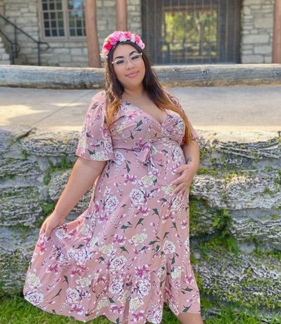 a pregnant reviewer wearing the pink floral dress