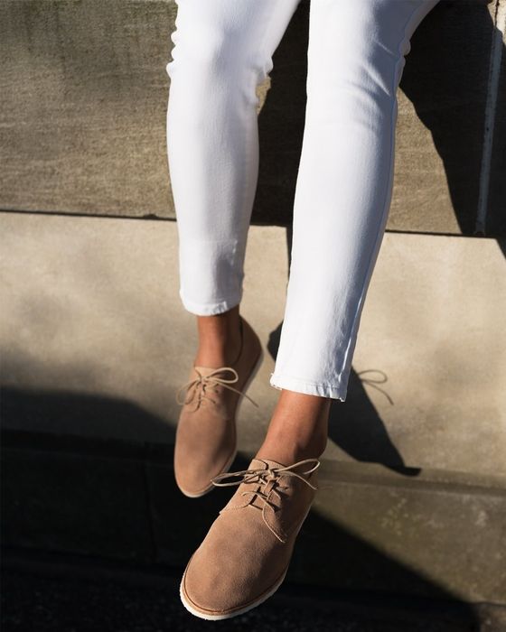 A model is sporting a pair of tan suede sneakers, effortlessly combining style and comfort.