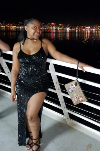 reviewer wearing a black dress on a boat