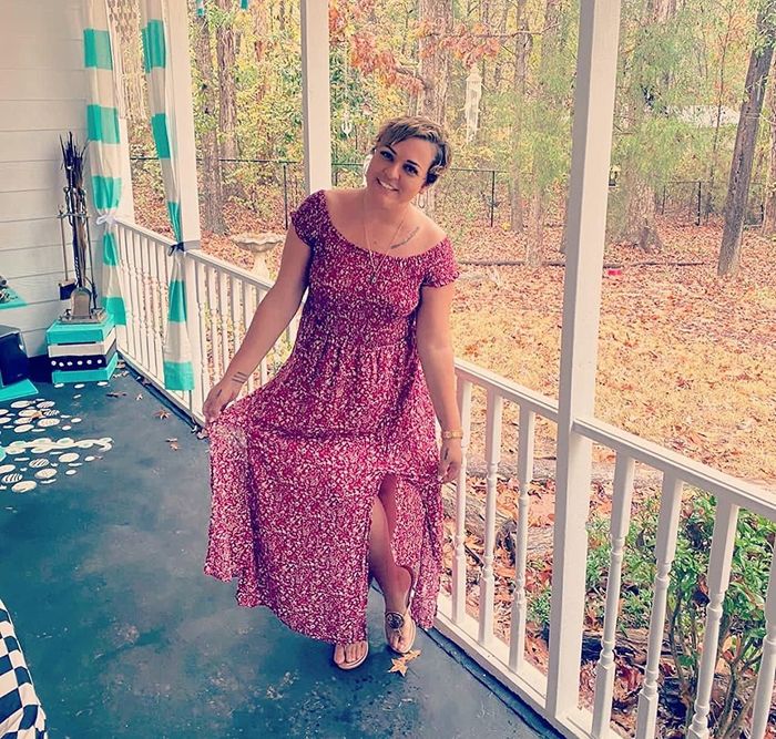 reviewer wearing the red dress while standing on a porch