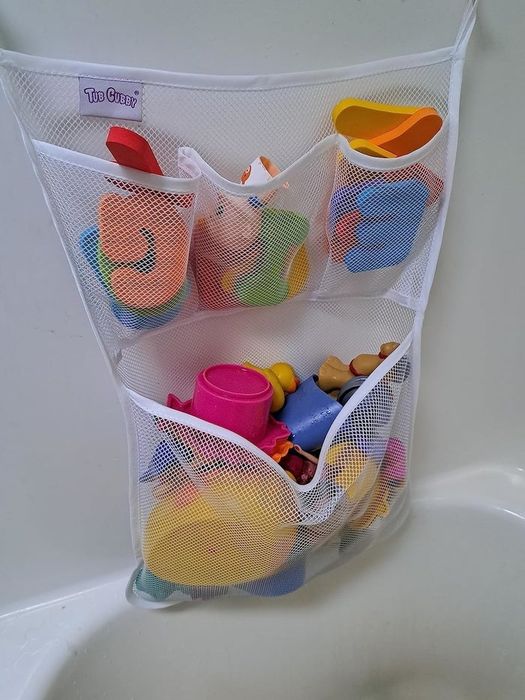 A mesh organizer holding various bath toys in a bathtub, perfect for keeping things neat and tidy.