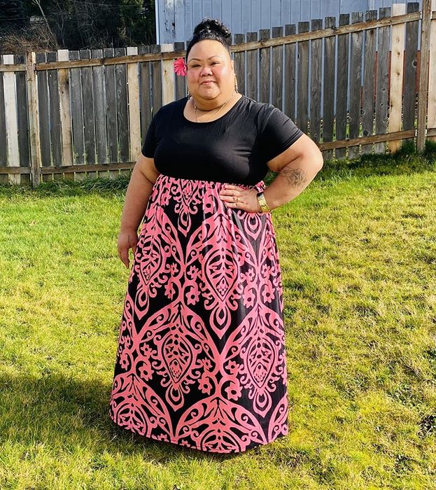 reviewer wearing the dress with a black top and a pink-patterned skirt