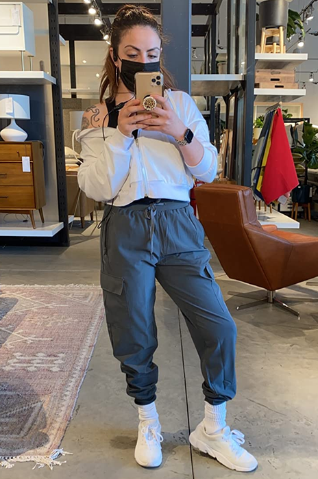 A reviewer is shown wearing the gray joggers paired with a white hoodie.